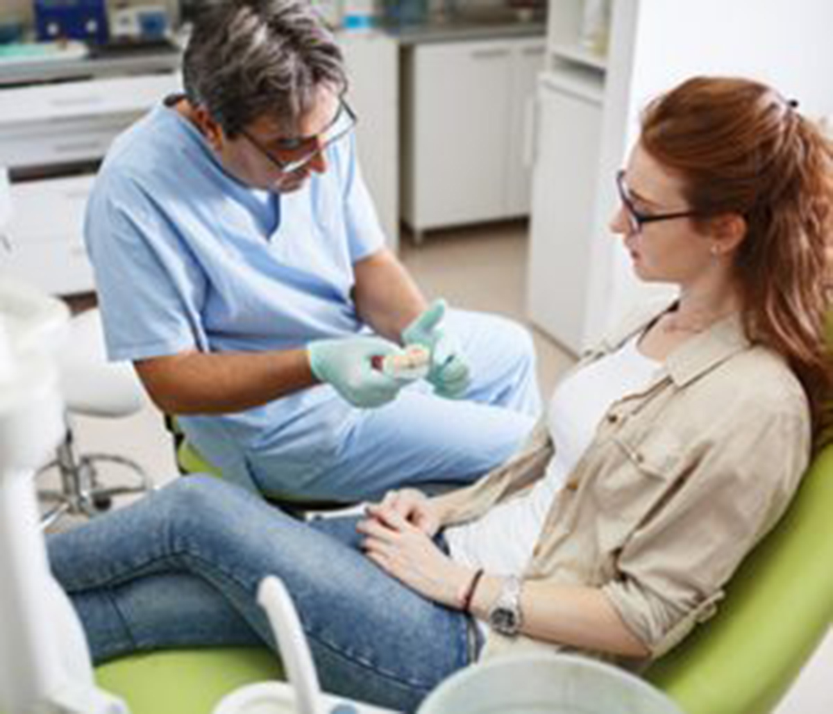 Senior male dentist with patient