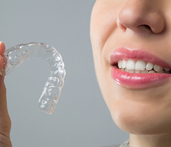 A woman holding a invisalign braces
